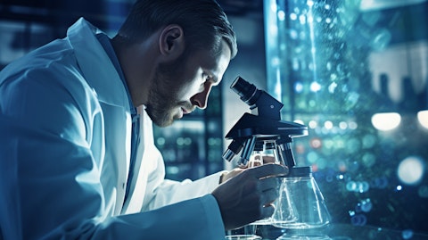 A scientist wearing a lab coat looking into a microscope examining a biopharmaceutical sample.