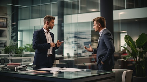 An executive in a modern office, discussing business developments with a client.