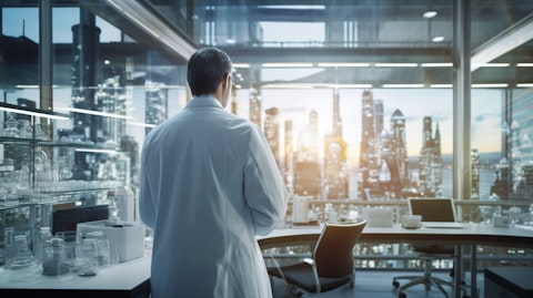 A clinician wearing a lab coat with a view of a biopharmaceutical lab in the background.