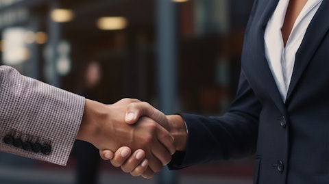 A close-up of a man in a business suit shaking hands with a woman representing a real estate company.