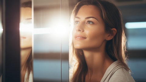 A woman in her late 30s looking into a mirror admiring her glowing skin.