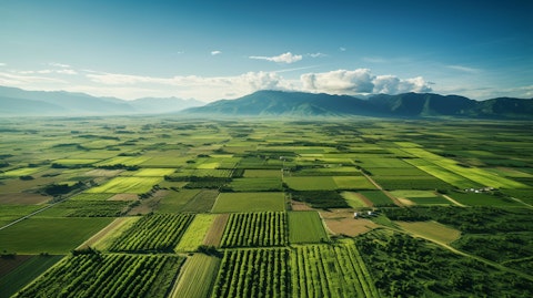 A wide aerial shot of a lush green farm, showing the sprawling land covering the horizon.