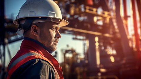 A close-up of a worker standing next to a high-specification rig at an oil field.