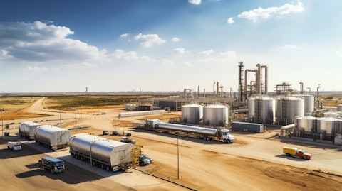 Aerial view of an oil and gas field, with tanker trucks in the foreground.