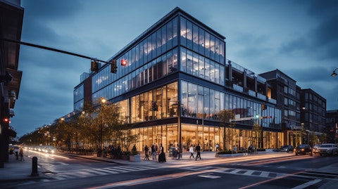 A large, multi-story commercial building, its net leased storefronts lit up in the evening.