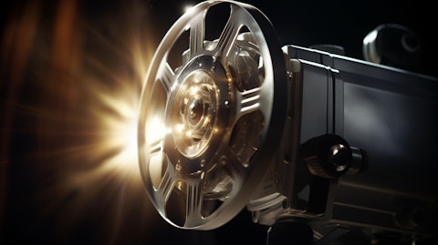 A close-up of a movie projector light casting onto a silver movie screen.