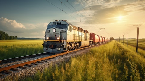 A large commercial freight train rolling through the countryside carrying steel products.