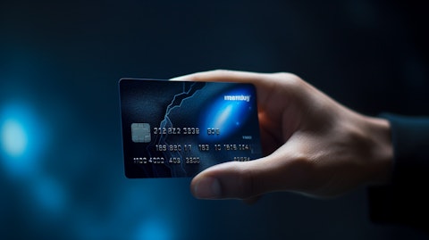 A closeup of a hand holding a debit card, representing the financial services the company provides.