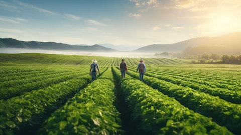 Farmers in a field surrounded by crop rows, nourished by agricultural inputs provided by the company.