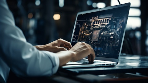 A close-up of an engineer using a laptop, delicately adjusting the settings of a connected machine.