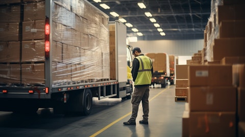 A worker loading goods onto a truck in a distribution center.