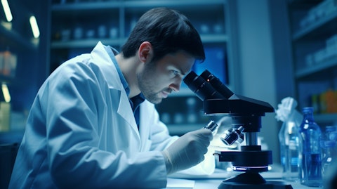 A cell biologist in a labcoat holding a microscope, microscoping a cell sample.