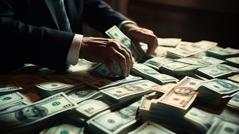 A close-up of a banker's hands counting stacks of freshly printed bank notes.