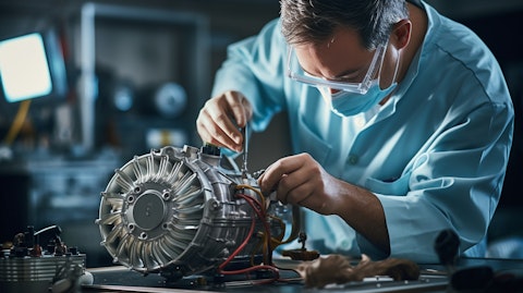 A technician assembling and testing a ventilator in a lab.