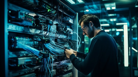 A technician in a high-tech office connecting voice and video services to a large scale network.