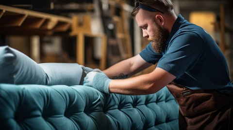 A closeup of a blue-collar worker producing a sofa for a retail company.