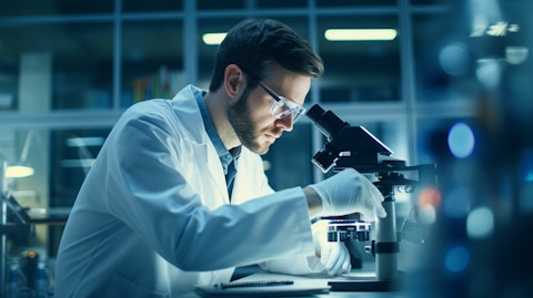 A Biopharma Scientist at a laboratory bench examining a sample under a microscope.