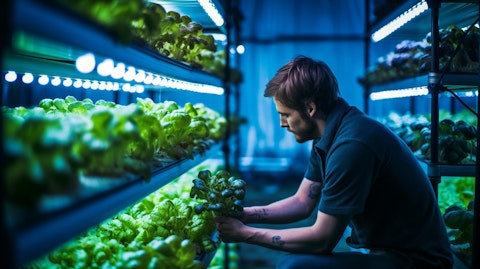 A farmer placing an accessory into a hydroponic system, filled with a nutrient-rich growing media.
