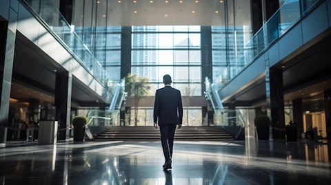 An executive in a suit walking in the lobby of a modern financial institution.
