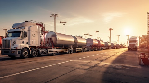 A bustling oil terminal with trucks and tankers lined up to receive fuel.