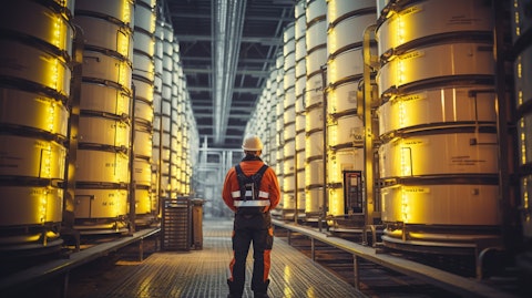 A technician wearing a safety vest standing alongside a commercial-scale energy storage stack.