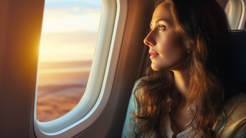 A passenger gazing out the airplane window, taking in the sights of her journey.