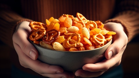 Close-up of a hand holding a bowl full of freshly cooked salty snacks.