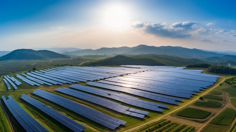 An aerial view of a solar power plant, the sun's rays illuminating the surrounding landscape.