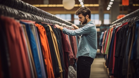 A customer shopping in a department store, browsing through racks of clothing.