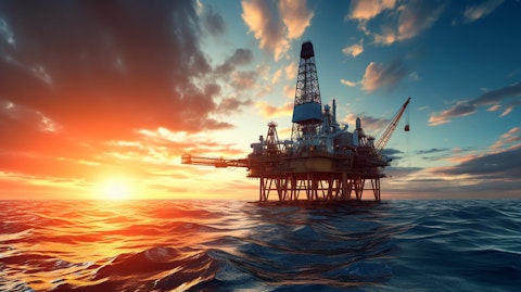 An oilrig in the middle of the ocean as the sun sets beyond the horizon.