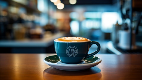 A freshly brewed cup of coffee on a barista's counter with the store's logo in the background.