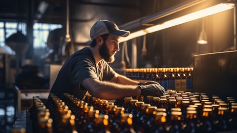 A brewery worker pouring bottles of freshly brewed beer into boxes, representing the company's alcoholic beer beverages.