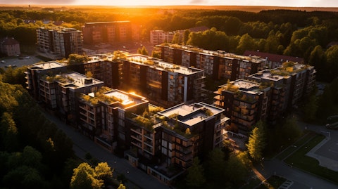 An aerial view of a residential building complex illuminated by a setting sun.
