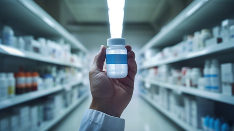 A pharmacist holding up a bottle of pharmaceutical grade product for inspection.