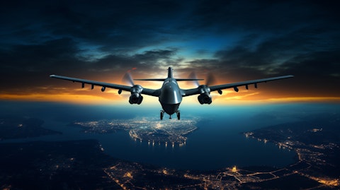 An unmanned aircraft system in the sky, its silhouette illuminated in the night light.