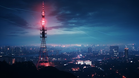 An FM radio tower in the metropolitan skyline with the broadcast company's branding.