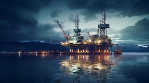 An oil rig under construction in the middle of a lake, its lights reflecting on the surrounding water.