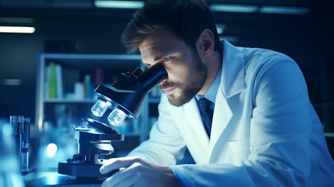 A scientist in a lab coat studying a microscope with a deep expression of concentration.