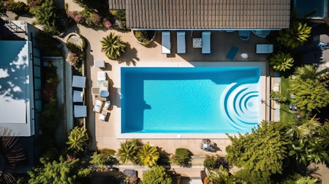 An aerial view of a real estate property with a pool in the backyard.