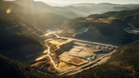 Aerial view of a gold mine in the mountains, trees reflecting the light from the sun.