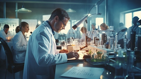 A busy pharmacological laboratory with a scientist and technician in white coats.