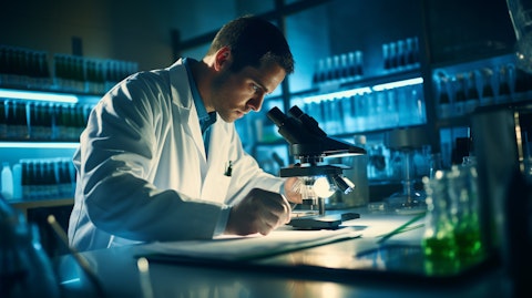 A researcher in the preclinical development stage working in a laboratory with test tubes and a microscope.