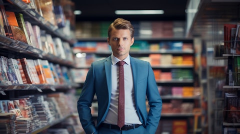 A business executive in a suit standing in front of a retail store shelf displaying one of the company's products.