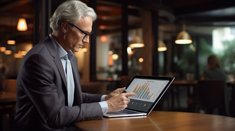 A senior corporate executive presenting a laptop screen of insights related to hospitality industry.