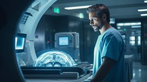 A technician in a medical facility overseeing the operation of a sophisticated imaging machine.