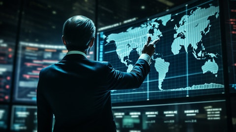 An executive wearing a suit waving a finger while standing in front of an international stock market graph.