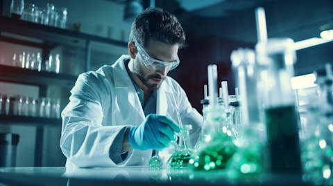 A scientist in a lab coat pouring a monoclonal antibody solution from a beaker.