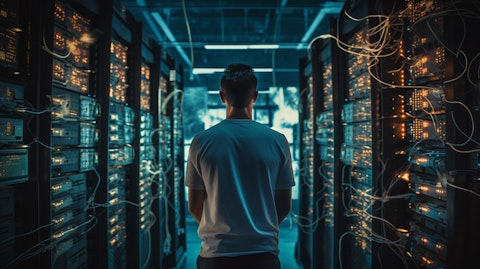 A technician standing in front of a wall of servers, managing the public wireless network.