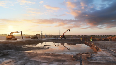 Early morning view of a well site construction in progress, with the sky and horizon a glowing backdrop.