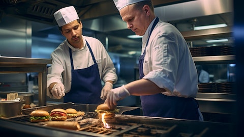Chefs in a fast-food kitchen preparing burgers and fries.